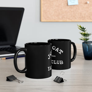 Two 11oz black ceramic mugs with white "JOAT Yacht Club 2020" design on a light wood desk.