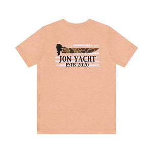 Light peach unisex cotton tee with "JON YACHT ESTB 2020" over a distressed camo and white striped flag.