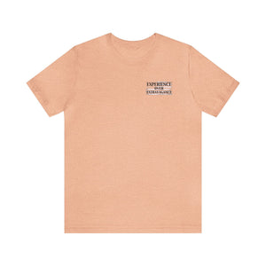 Peach unisex jersey t-shirt with "EXPERIENCE OVER EXTRAVAGANCE" text on the left chest.