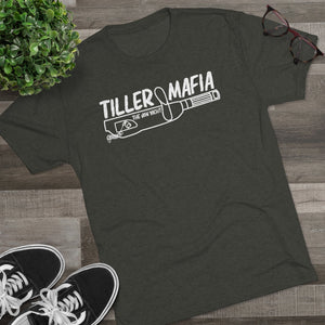 Dark gray tri-blend "Tiller Mafia" graphic tee with white design, black sneakers, plant, and glasses.