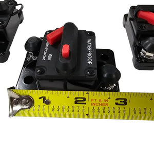 Black 60A waterproof circuit breaker with red reset button, shown with a tape measure for size.