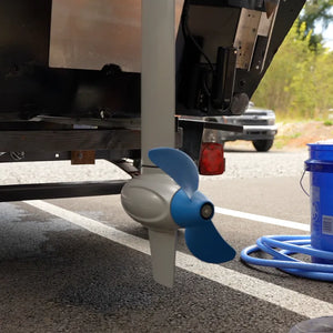 EPropulsion Spirit 1.0 Plus 3HP electric outboard motor mounted on a truck, with a blue hose connected to a pump.