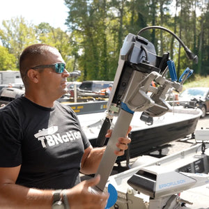 Man in a black shirt stands beside the EPropulsion Spirit 1.0 Plus 3HP electric outboard motor.