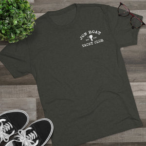 Dark gray tri-blend tee with "Jon Boat Yacht Club" logo, black sneakers, plant, and glasses.