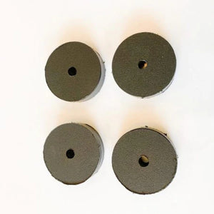 Four dark gray round UHMW motor clamp spacers, 1-inch thick, with a central hole.