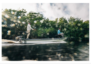 Newport NT600 6hp electric outboard on a white jon boat with two people, cruising through mangroves.