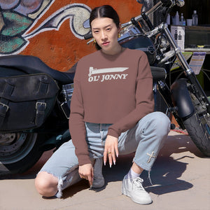 Woman in Ol' Jonny brown cropped sweatshirt, light wash jeans, and white sneakers, next to a motorcycle.