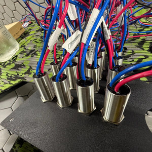Silver 22mm Plashlights REVERT marine switches with blue and red wires, mounted on a black panel.
