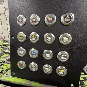 Black panel with sixteen 22mm round, silver metal Plashlights REVERT boat switches, each with a custom icon.