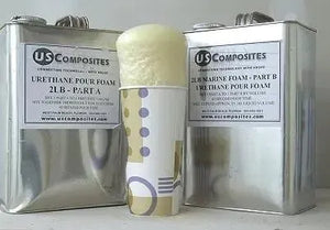 Two silver US Composites cans of 2 Lb density urethane pour foam, with a paper cup of expanded foam in the center.