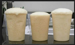 Three clear plastic cups filled with expanding, light tan pour foam.