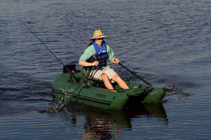 Man in straw hat and life vest rowing a green Sea Eagle pontoon boat with black oars.