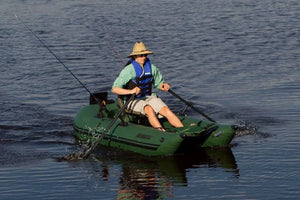 Man in straw hat and life vest rowing a green Sea Eagle pontoon boat with black oars.