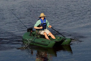 Man in straw hat and life vest rowing a green Sea Eagle pontoon boat with black oars.