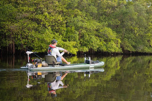 Green Sea Eagle iSUP with a swivel seat fishing rig, Scotty rod holders, and a man fishing.