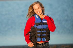 Smiling woman in a blue and black Sea Eagle S/M life jacket with four adjustable straps.