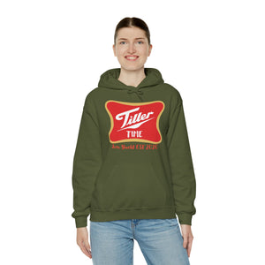 Woman smiling in an olive green "Tiller Time" hoodie with a red and gold graphic, kangaroo pocket.