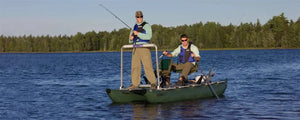 Two men fishing from a dark hunter green Sea Eagle 375fc FoldCat inflatable pontoon boat on a lake.