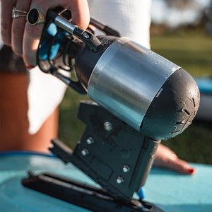 Close-up of a person using a nail gun with a blurred outdoor background