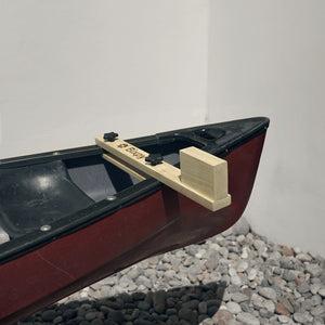 Model canoe with a wooden oar on a white background