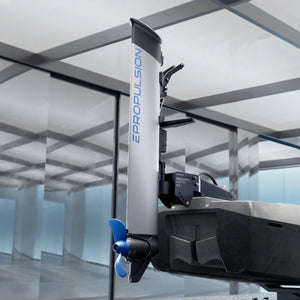 A close-up of an ePropulsion kLite 7500 electric boat motor and propeller assembly mounted on a hull, with the vertical shaft labeled EPROPULSION. The product is shown in a modern indoor studio or showroom setting with glass walls and ceiling panels.
