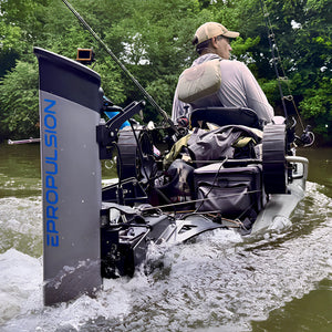 A person sits in a motorized fishing boat on a river, viewed from behind. The boat has a large gray and black Epropulsion propeller unit on the left side, fishing rods, gear bags, and a green forest in the background.