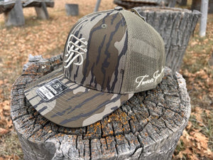 Camouflage baseball cap with mesh back on a wooden stump outdoors