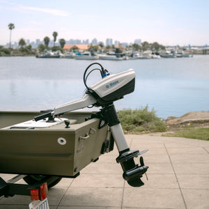 Bixpy Outboard motor on a trailer with a waterfront background
