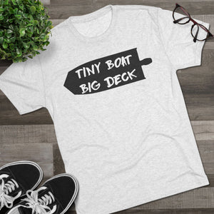White t-shirt with 'Tiny Boat Big Deck' text on a wooden surface with shoes and glasses.