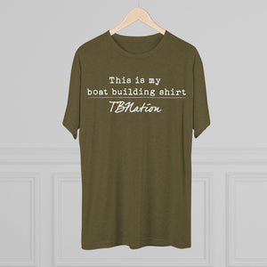 Green t-shirt with text on a hanger against a gray background