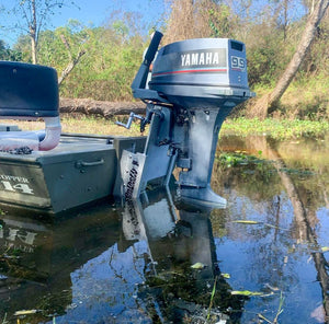 Silver OnTheFly Electric Jackplate mounted on a green boat with a Yamaha 9.9 outboard motor in water.