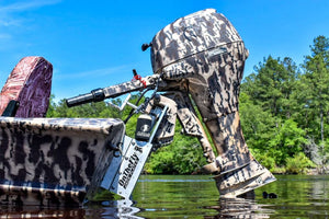 OnTheFly Manual Jackplate in silver and black, mounted on a camo boat with an outboard motor.