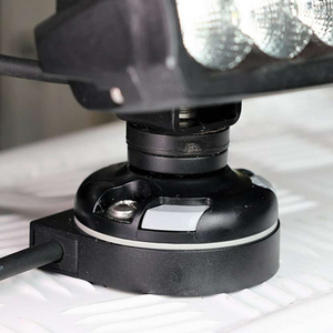 Black Railblaza E Series Cable Entry Port Base with a light gray locking tab, mounted on a white textured surface.