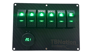 Black carbon fiber 6-gang rocker switch panel with green LED switches, voltmeter, and TBNation Outdoors logo.