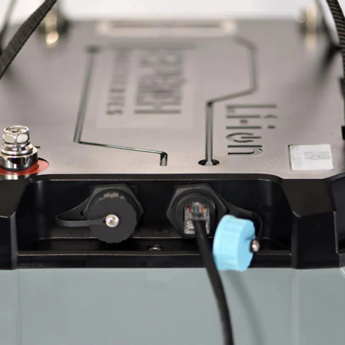 Close-up of a gray and black Epoch marine lithium battery with a terminal, sealed port, and connected Ethernet cable.