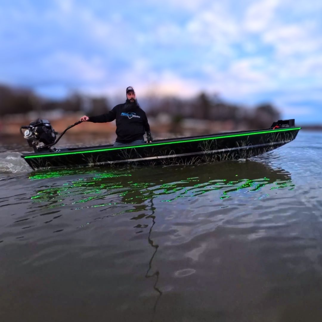 Custom Espresso over Black 1436 duck boat with green LED lights, 13hp mud motor, and driver on water.