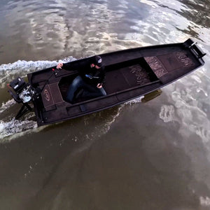 Custom espresso over black 1436 duck boat with a mud motor, driven by a person on the water.