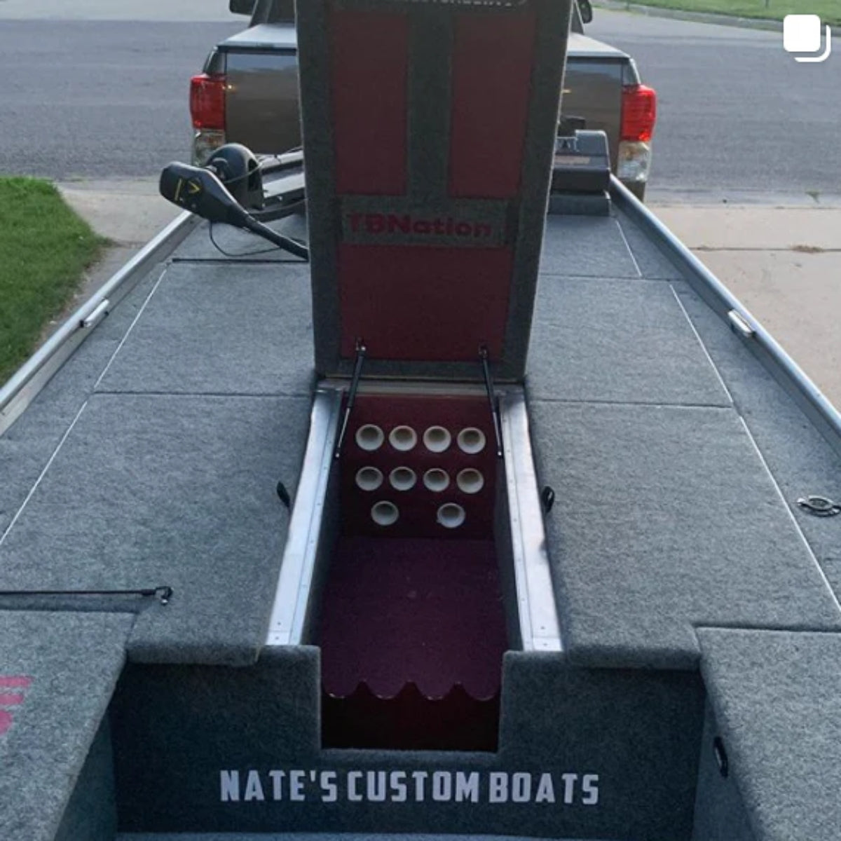 Charcoal gray cut pile marine grade boat carpet installed in a jon boat, showing a red storage compartment.