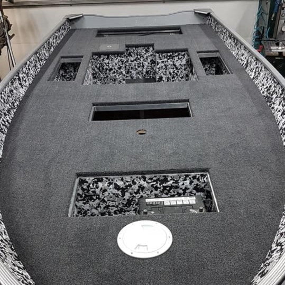 Dark gray cut pile marine carpet installed in a boat, with black and white patterned accents.