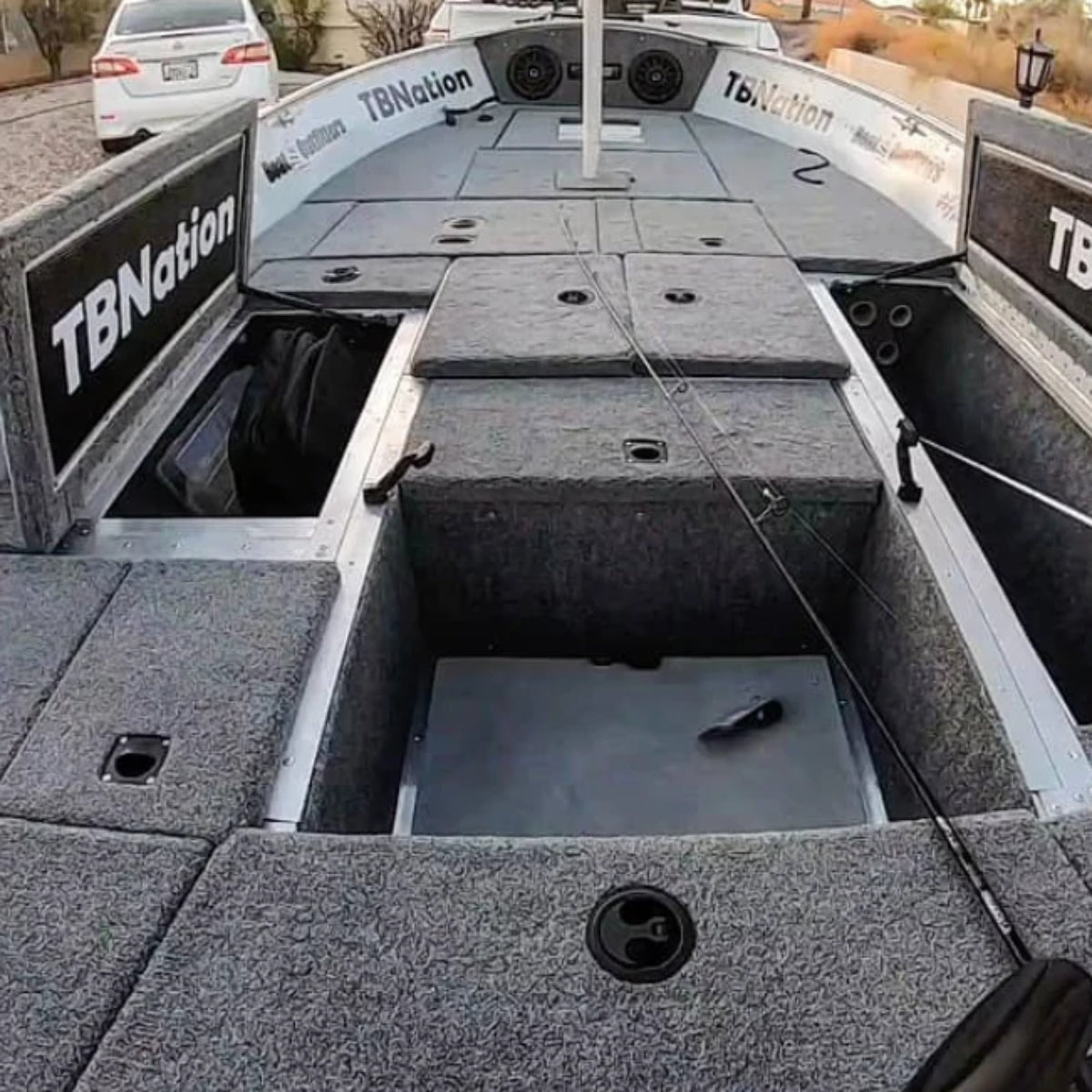 Gray 20 oz cut pile marine grade boat carpet installed on a bass boat deck with open storage compartments.