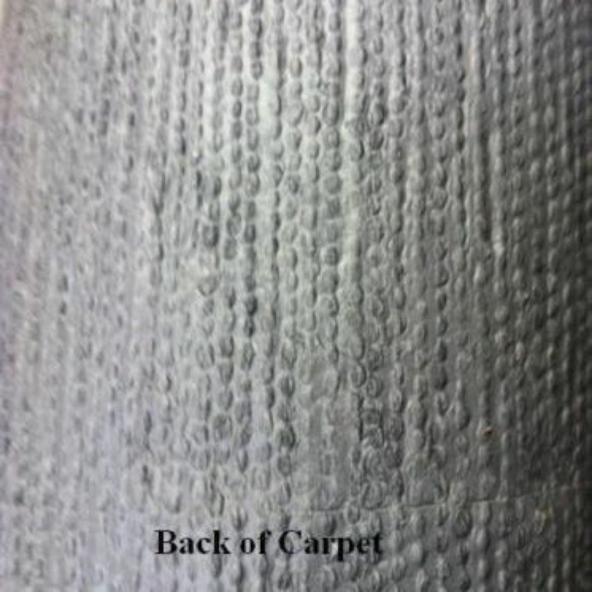 Close-up of the textured, dark gray backing of 20 oz cut pile marine grade boat carpet.
