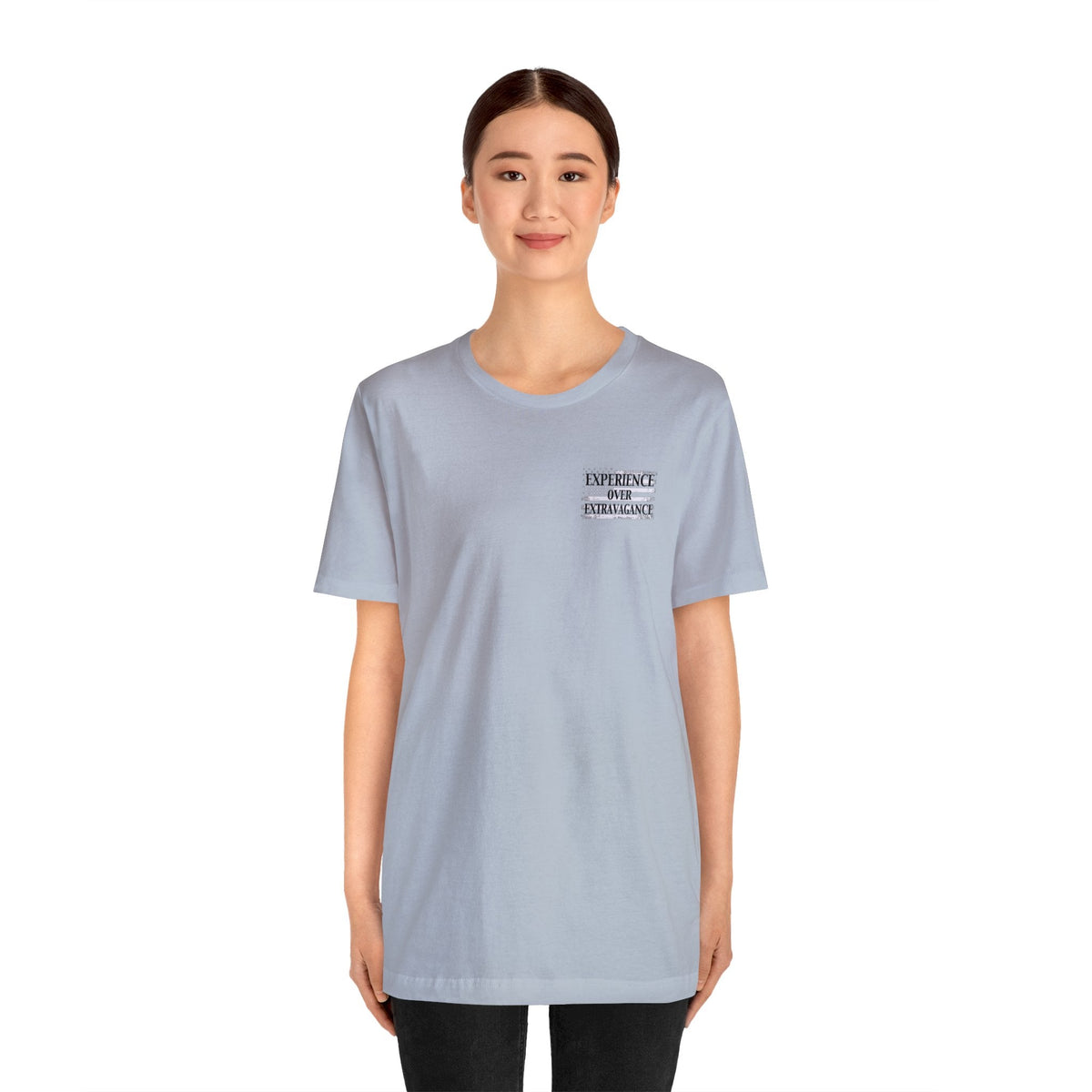 Light blue unisex t-shirt with "EXPERIENCE OVER EXTRAVAGANCE" text on the left chest.