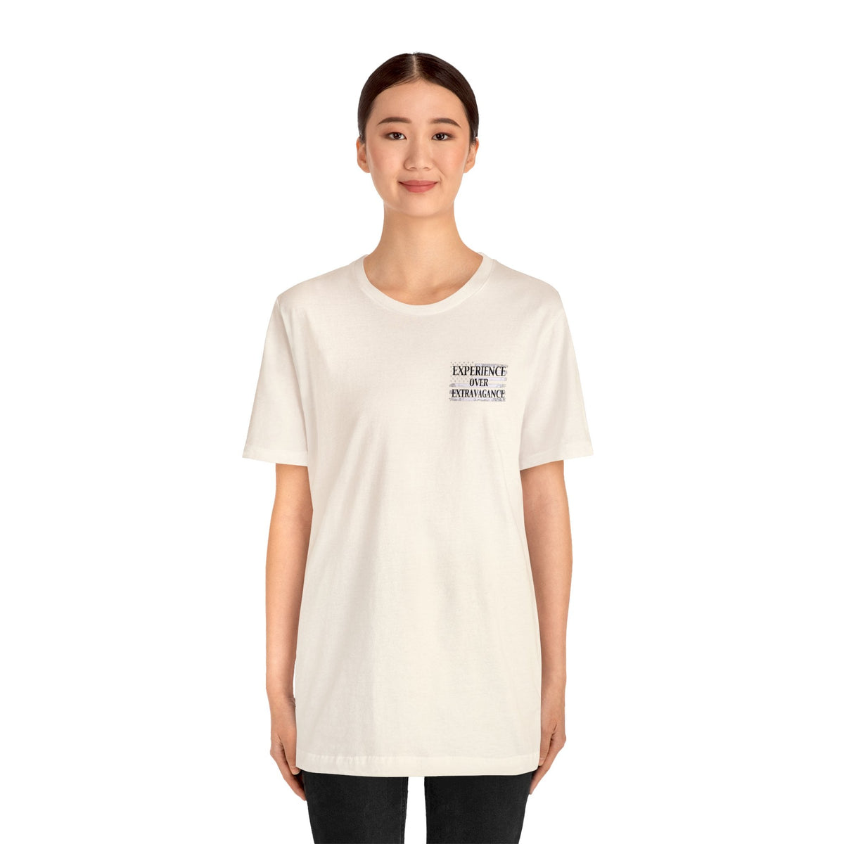 Woman wearing a light cream unisex jersey t-shirt with "EXPERIENCE YOUR EXTRAVAGANCE" text on the left chest.