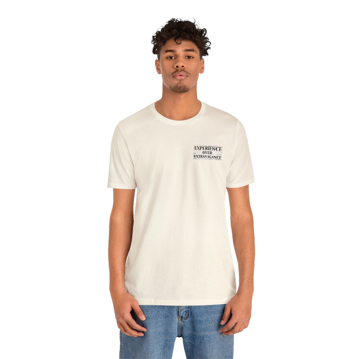 Man in a cream "American Dreamer" t-shirt with "EXPERIENCE OVER EXTRAVAGANCE" text on the left chest.