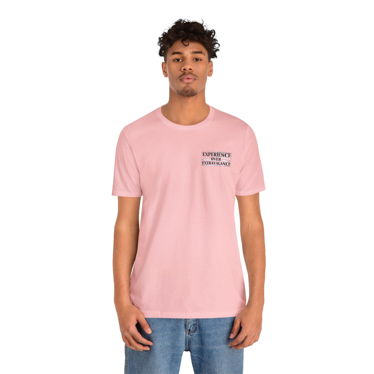 Man in a light pink American Dreamer t-shirt with "EXPERIENCE OVER EXTRAVAGANCE" text.