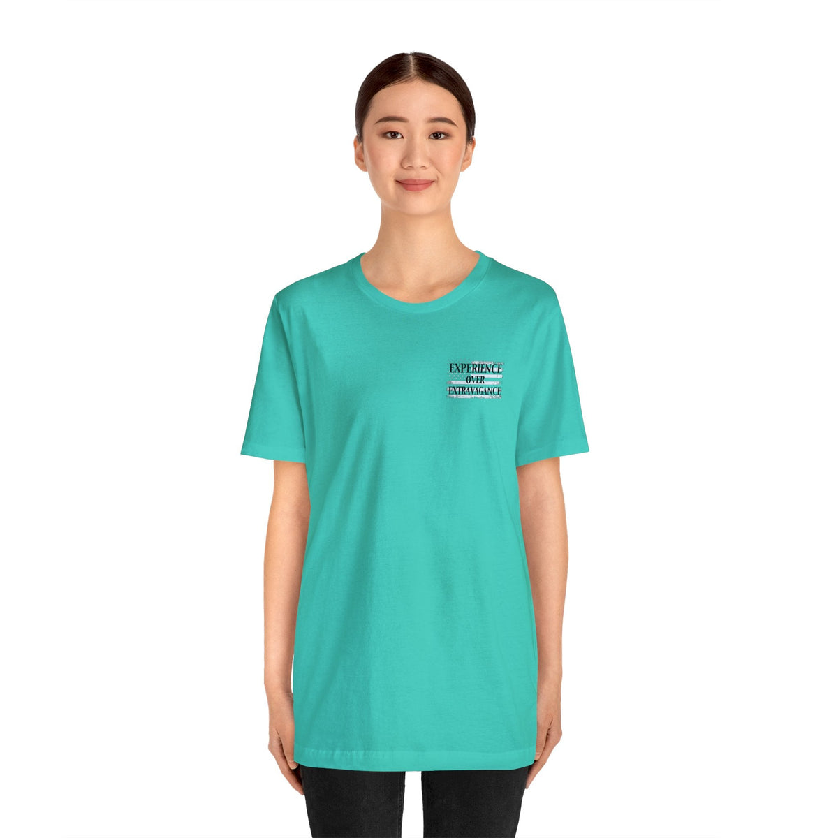 Woman wearing a turquoise "American Dreamer" unisex short sleeve tee with "EXPERIENCE OVER INTELLIGENCE" text.