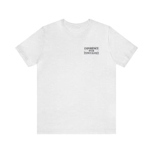 White unisex jersey short sleeve tee with "EXPERIENCE OVER EXTRAVAGANCE" text on the chest.