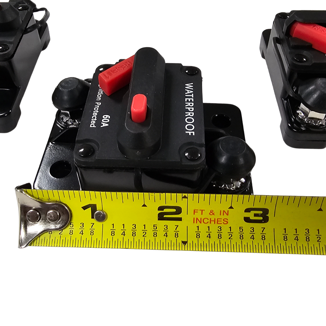 Black 60A waterproof circuit breaker with red reset button, shown with a tape measure for size.