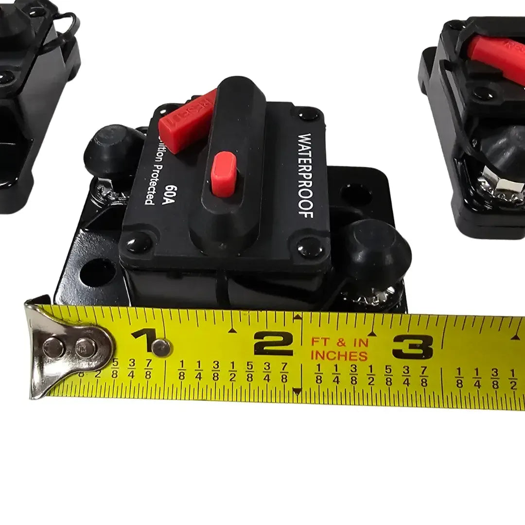 Black 60A waterproof circuit breaker with red reset button, shown with a tape measure for size.