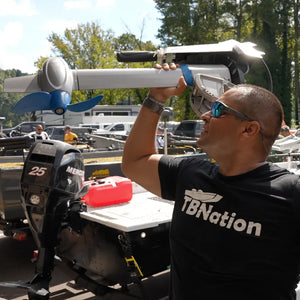 A man wearing a black shirt poses next to the EPropulsion Spirit 1.0 Plus 3HP electric outboard motor. 